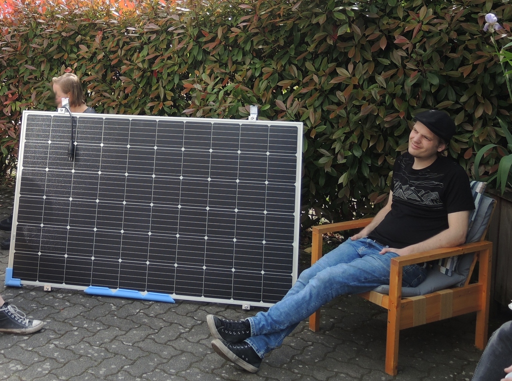 Ein Wissenschaftler sitzt vor einem Solar-Panel